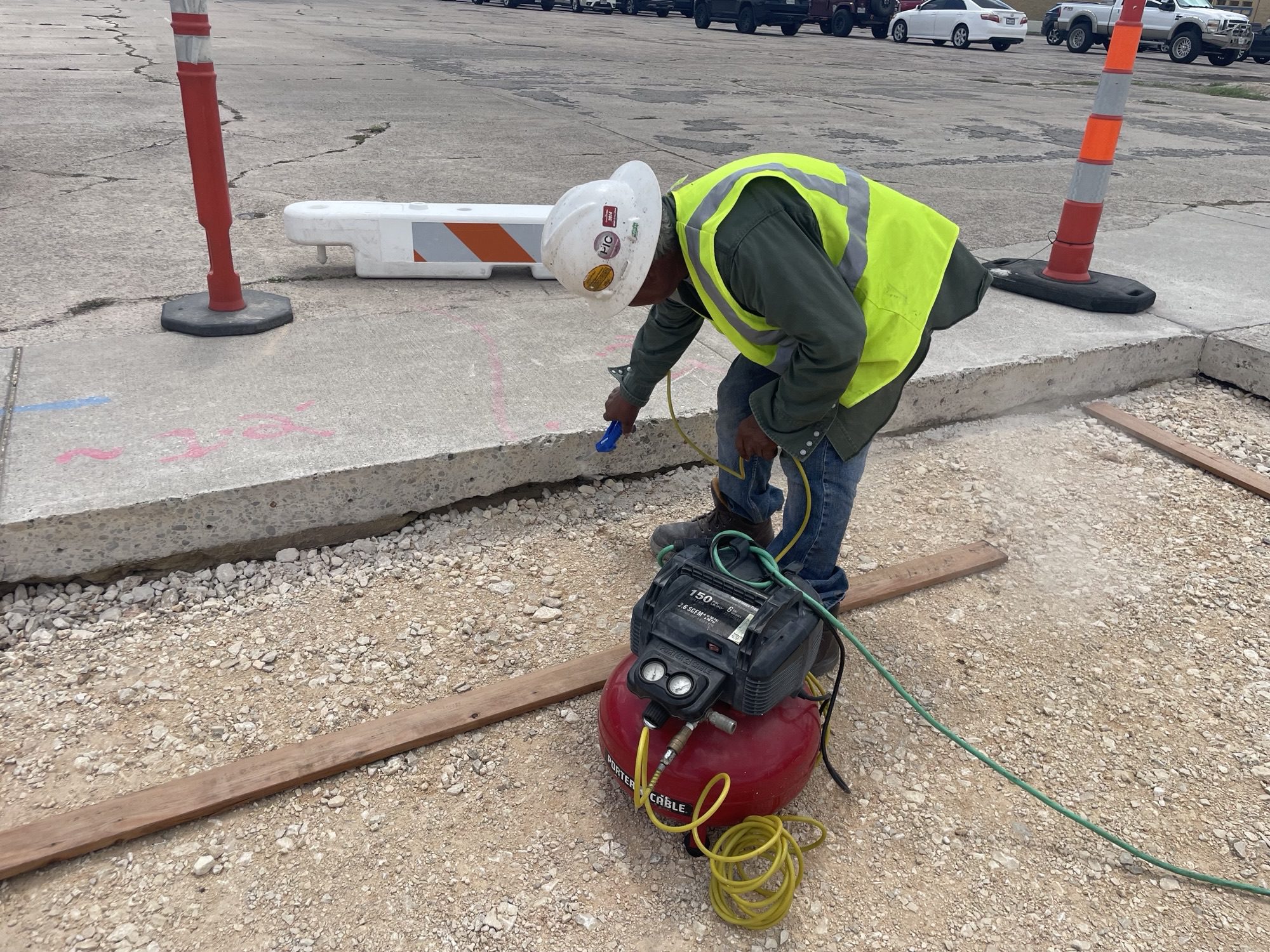 Worker marking pavement with spray paint